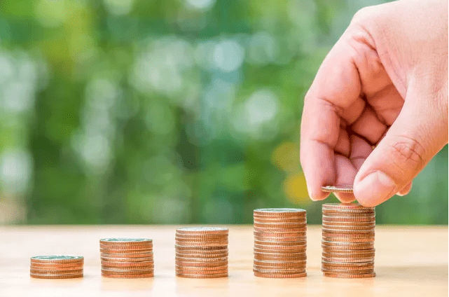 A person is stacking coins on top of each other.