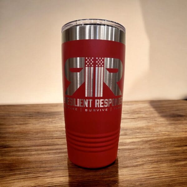 20 oz insulated tumbler with The Resilient Responder mug Sitting on counter.