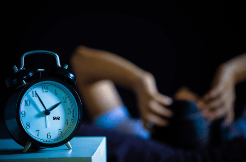 Insomnia Person trying to sleep with an alarm clock